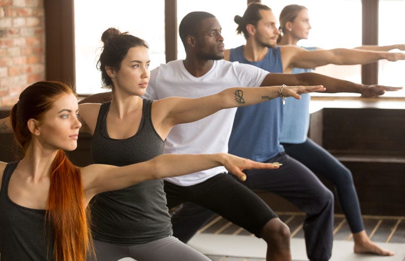 Multicultural people exercising in yoga class